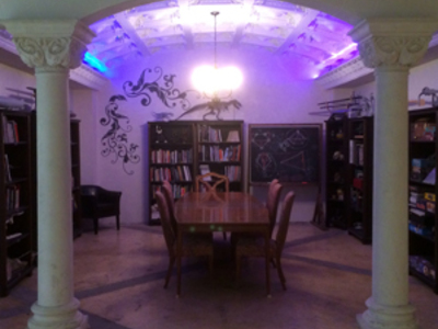 Our library set is equipped with a table and seating for 8, surrounded by bookshelves filled with books, games, and props, and can be dressed to meet other creative needs. 	